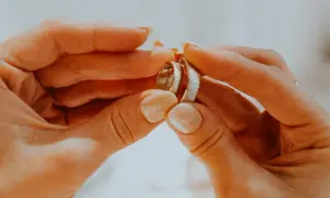 Dłonie trzymają dwie obrączki, symbolizujące miłość i wierność. Co oznacza obrączka na lewej ręce? To znak zaręczyn lub małżeństwa.