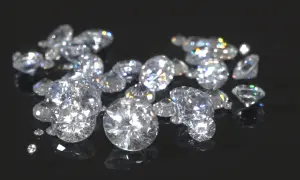 Klejnoty lśniące jak gwiazdy, pokazujące jak wygląda diament. Ich blask odbija się na czarnym tle.