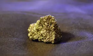 Błyszczący, złoty piryt, znany jako "złoto głupców", lśni na ciemnym tle. To fascynujący minerał, który często mylono ze złotem.