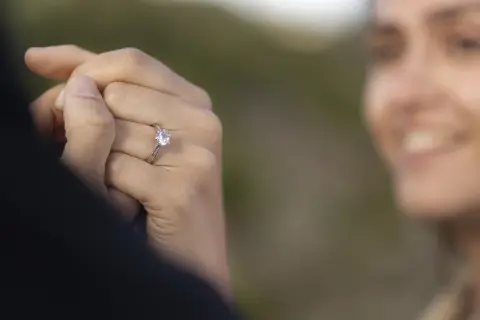 Delikatne pierścionki z diamentem, idealne jako pierścionki zaręczynowe. Biżuteria z diamentami na dłoni z jasnoróżowym manicurem.